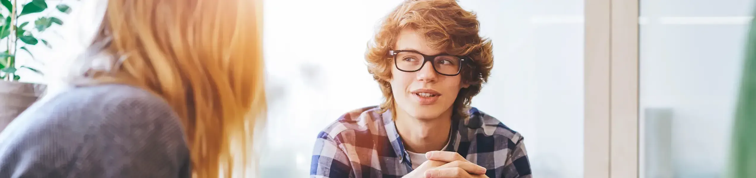 Eine AM-Mitarbeiterin spricht mit einem Auszubildenden über seine Stelle als IT-Fachinformatiker bei der AM GmbH.