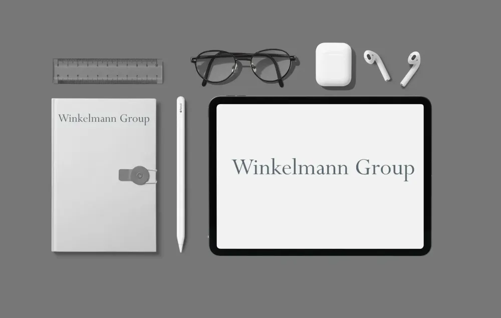 Winkelmann Group User-Helpdesk Büroutensilien mit Winkelmann-Group-Logo vor grauem Hintergrund.
