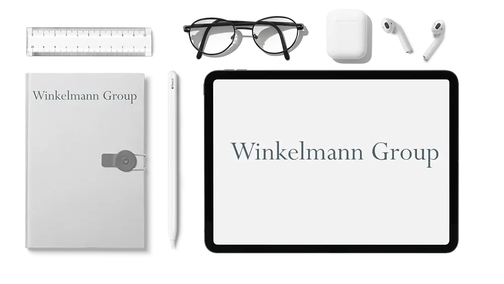 Büroutensilien mit Winkelmann Group Logo liegen auf einer Schreibtischplatte